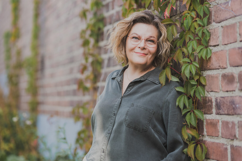 Coach ja valmentaja Pauliina Silvennoinen nojaa tiiliseninään ja katsoo kohti